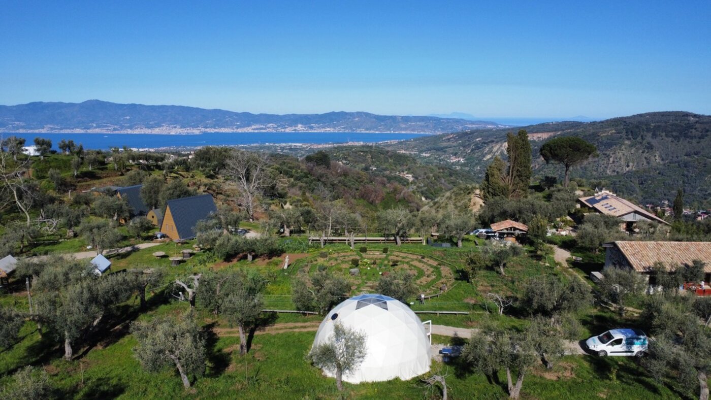 Vista drone di Gaya: cupola, A-frame, ulivi e Stretto di Messina