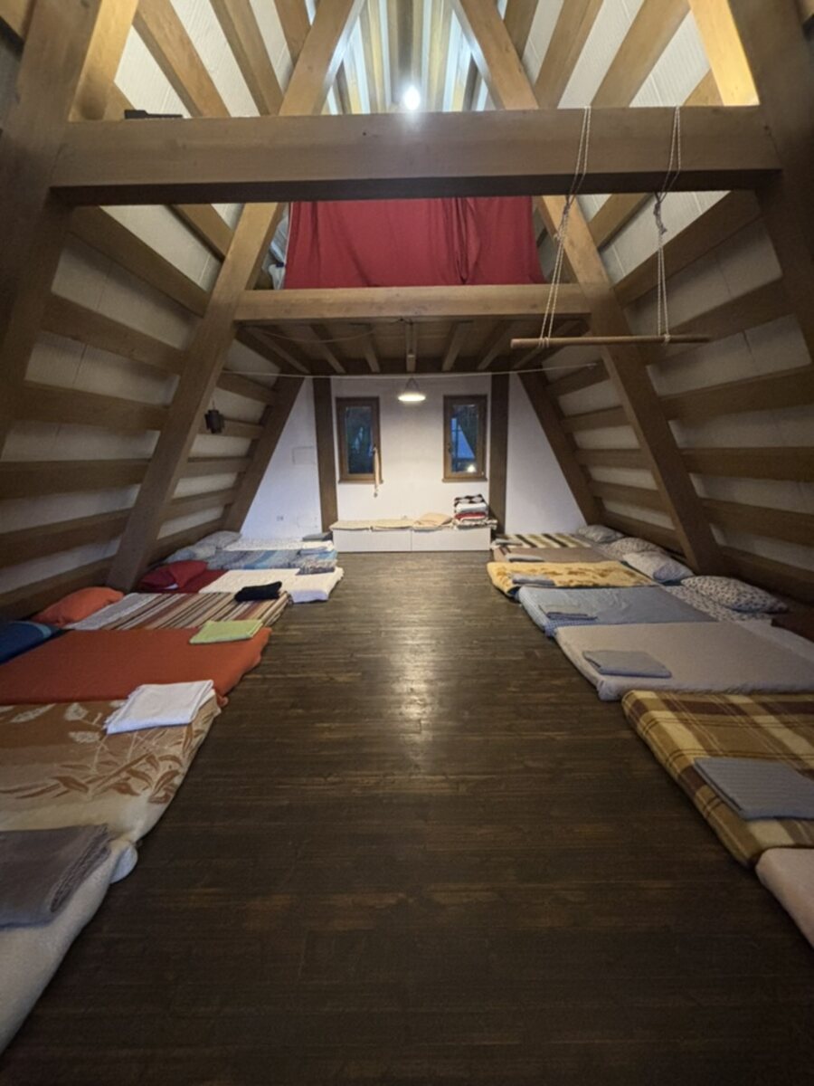 Interno del Salone dormitorio A-frame di Gaya con materassi e finestra triangolare
