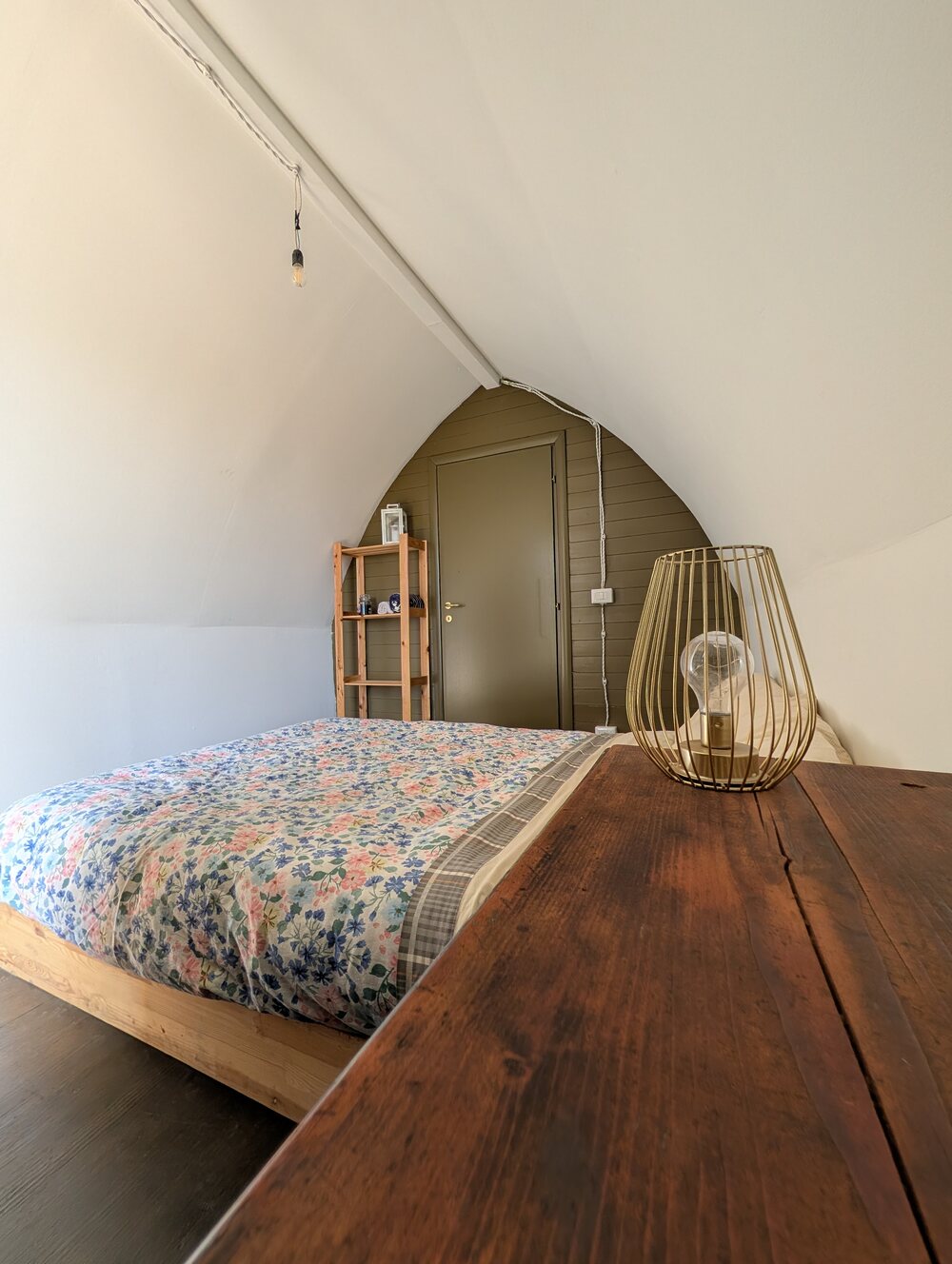 Interno del Seme: letto e lampada in vimini, tetto a sesto acuto bianco
